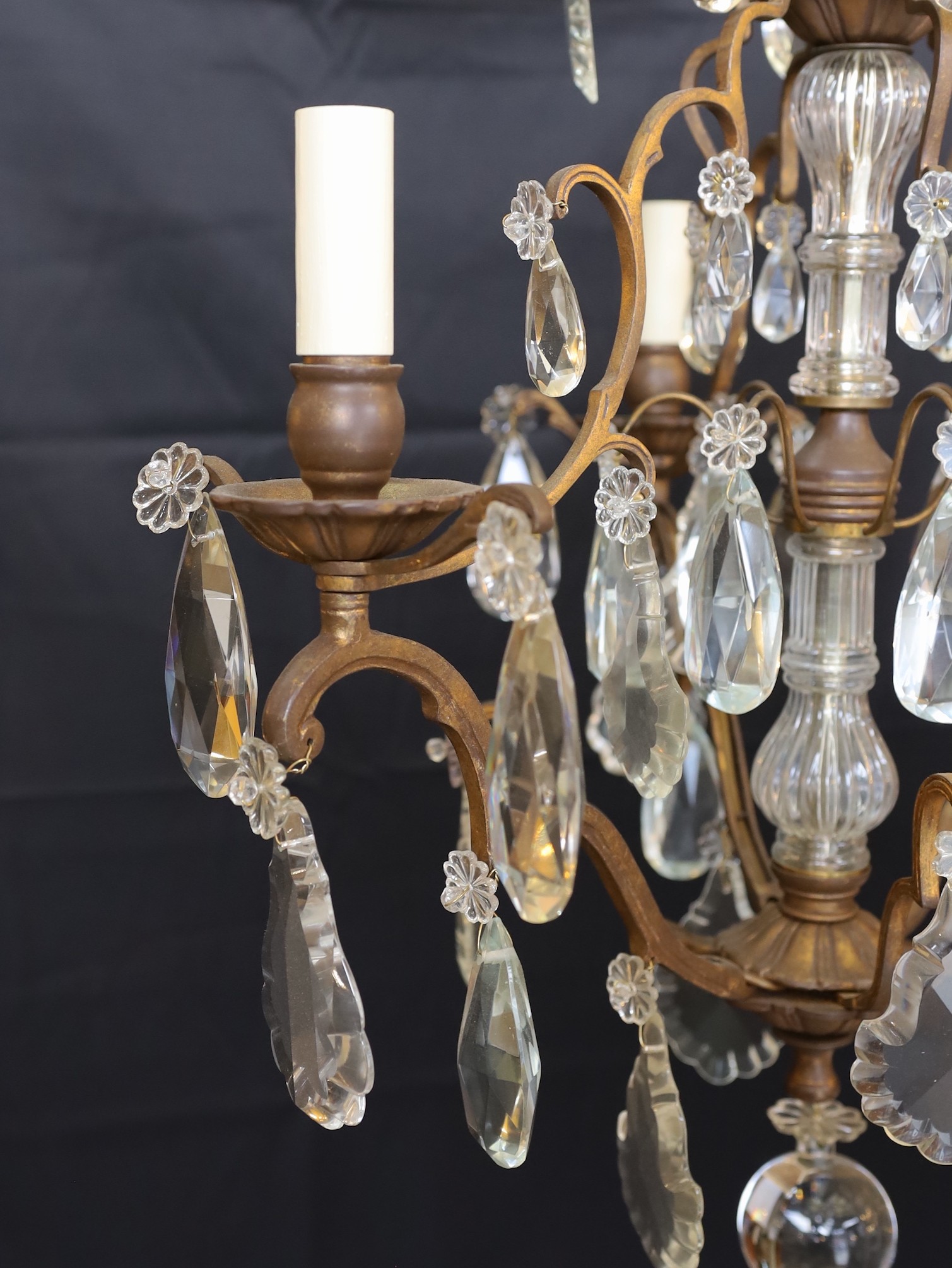 An early 20th century French bronze and cut glass three light chandelier, hung with tear shaped and faceted drops, height 64cm. width 50cm